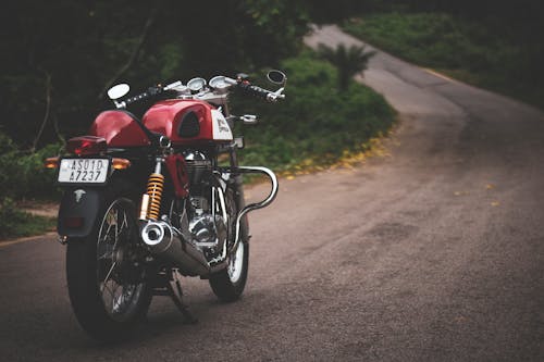 농장 도로에 주차 된 빨간색 표준 오토바이