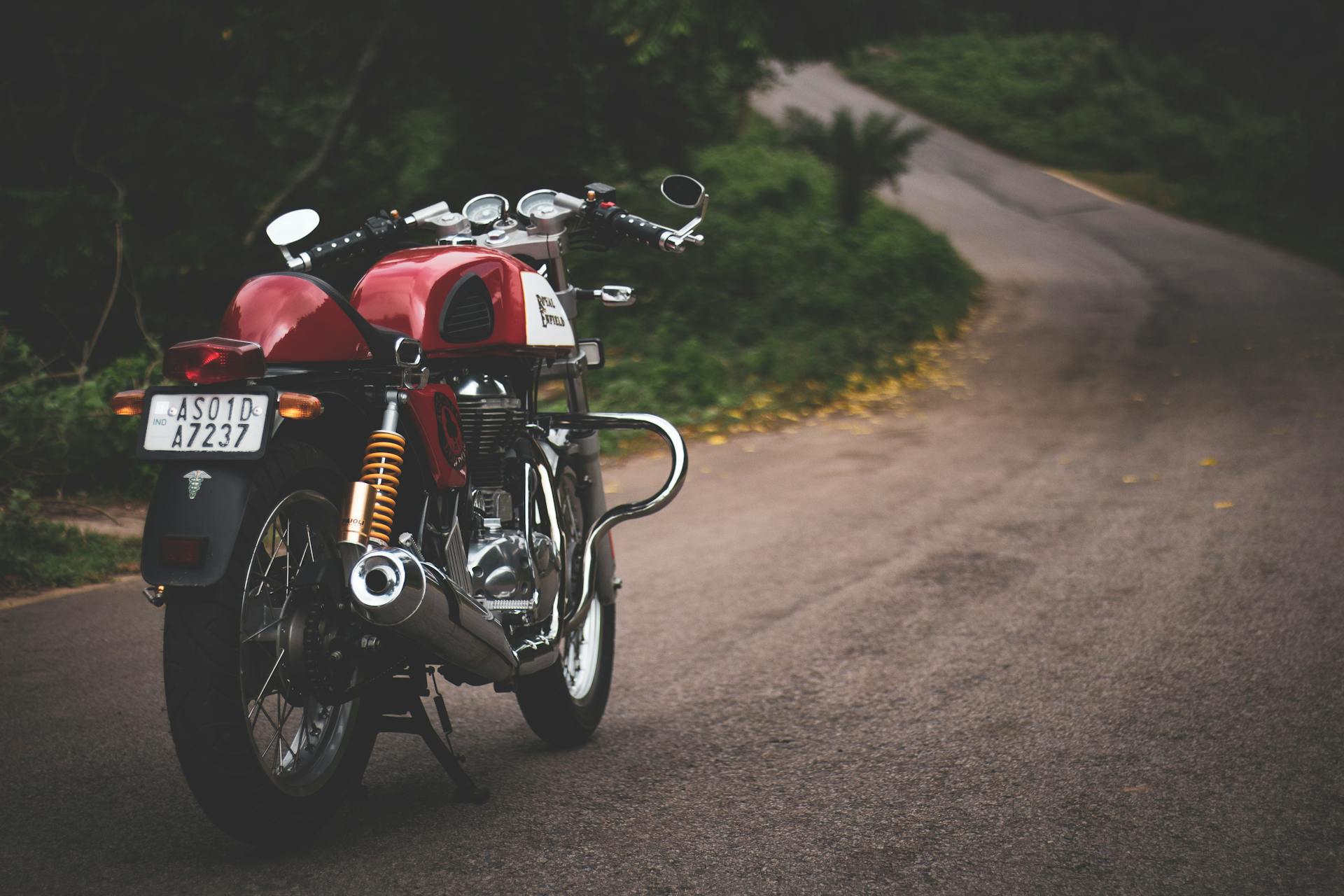 Red Standard Motorcycle Parked on Farm Road