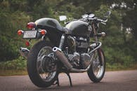 一辆停在户外的老式摩托车，以其时尚的设计和镀铬细节引人注目