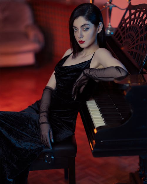 Woman in Black Dress by Piano