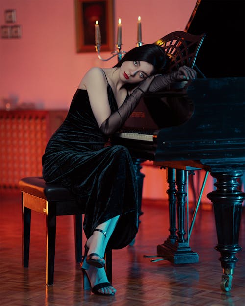 Woman in Black Evening Dress Leaning Head on Piano