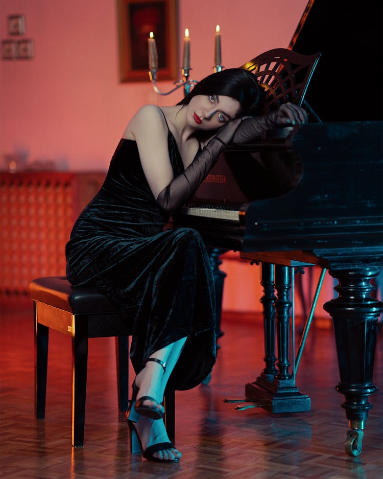 Woman In Black Evening Dress Leaning Head On Piano