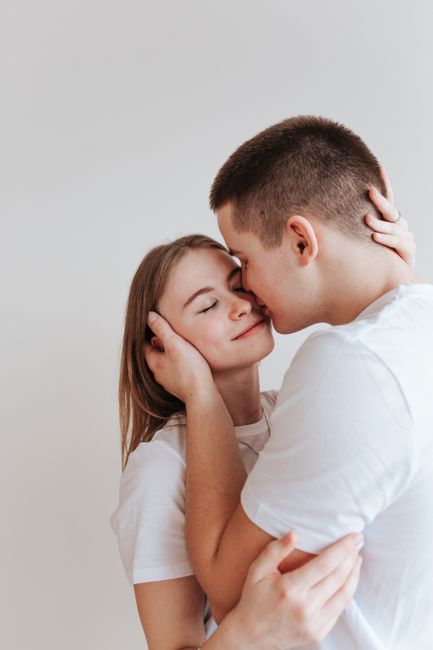 Young couple sharing a tender moment indoors, portraying affection and love.