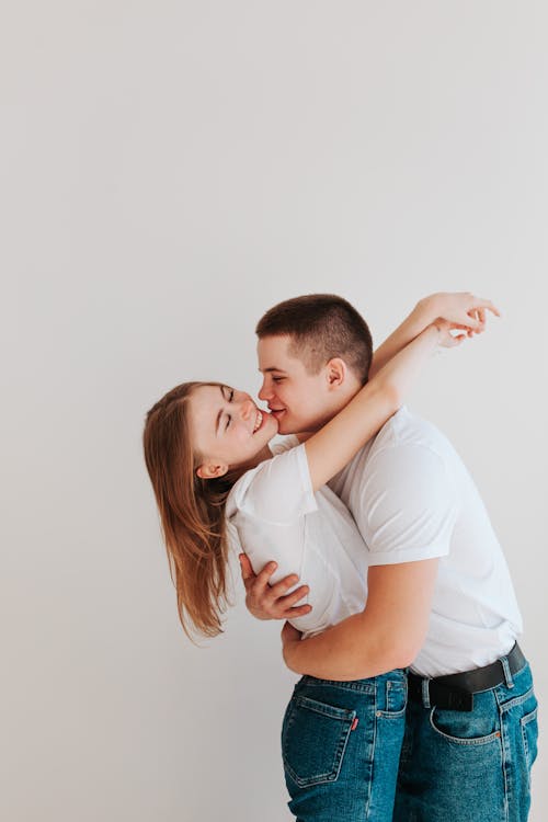 A Young Couple Hugging and Smiling 