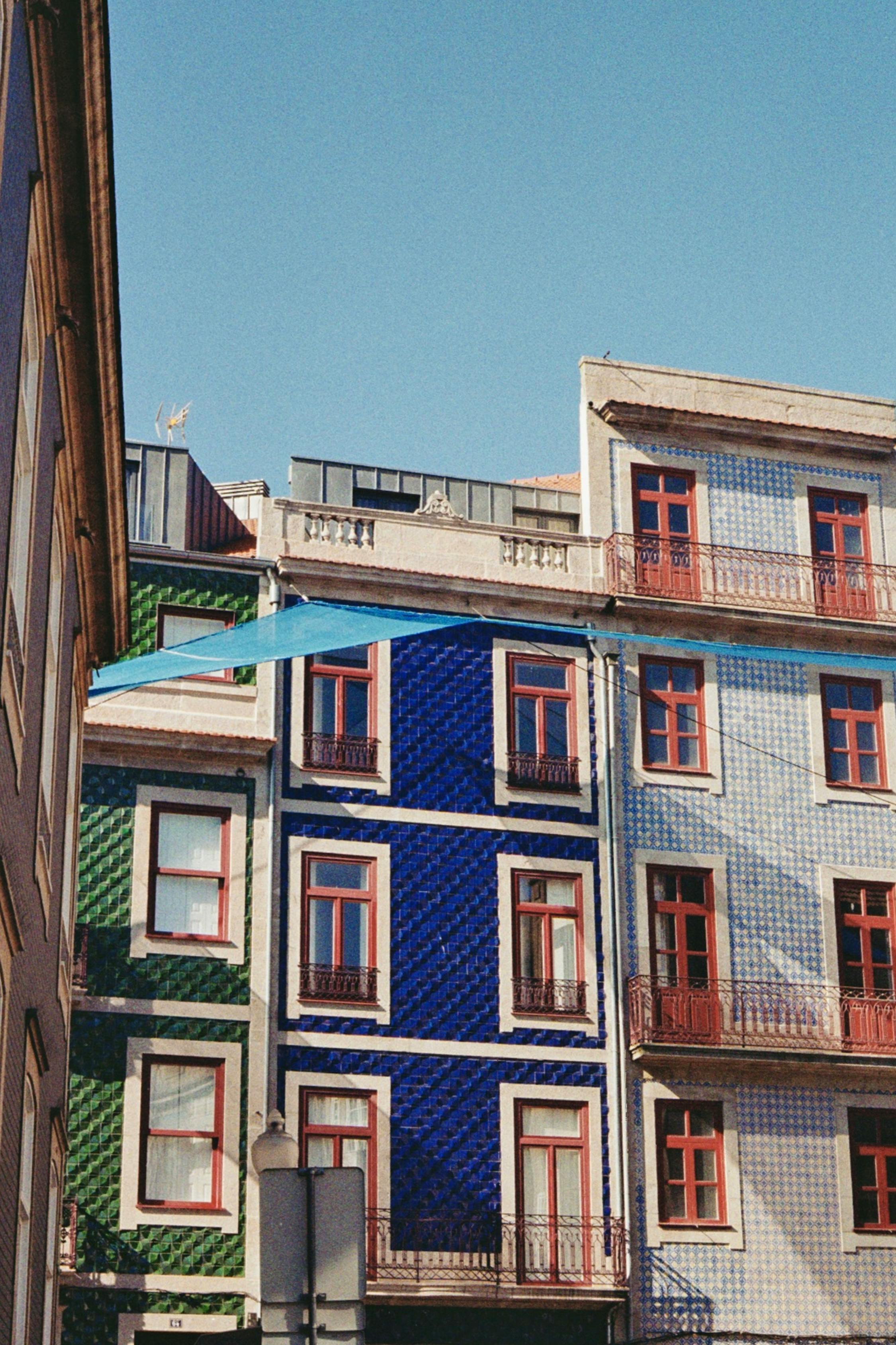 Vertical shot capturing the vibrant tiled facades of townhouses in Porto, Portugal.