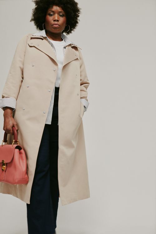 Free Sophisticated fashion portrait of a woman in a beige coat with pink handbag. Perfect for style inspirations. Stock Photo