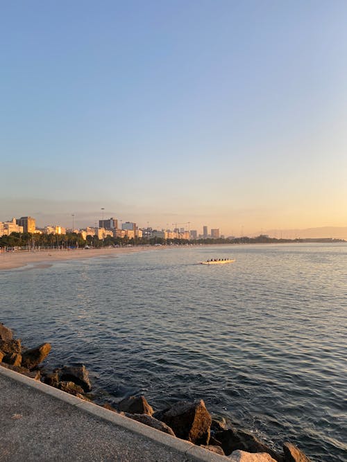 View of the Beach and a Coastal City in the Horizon at Sunset 