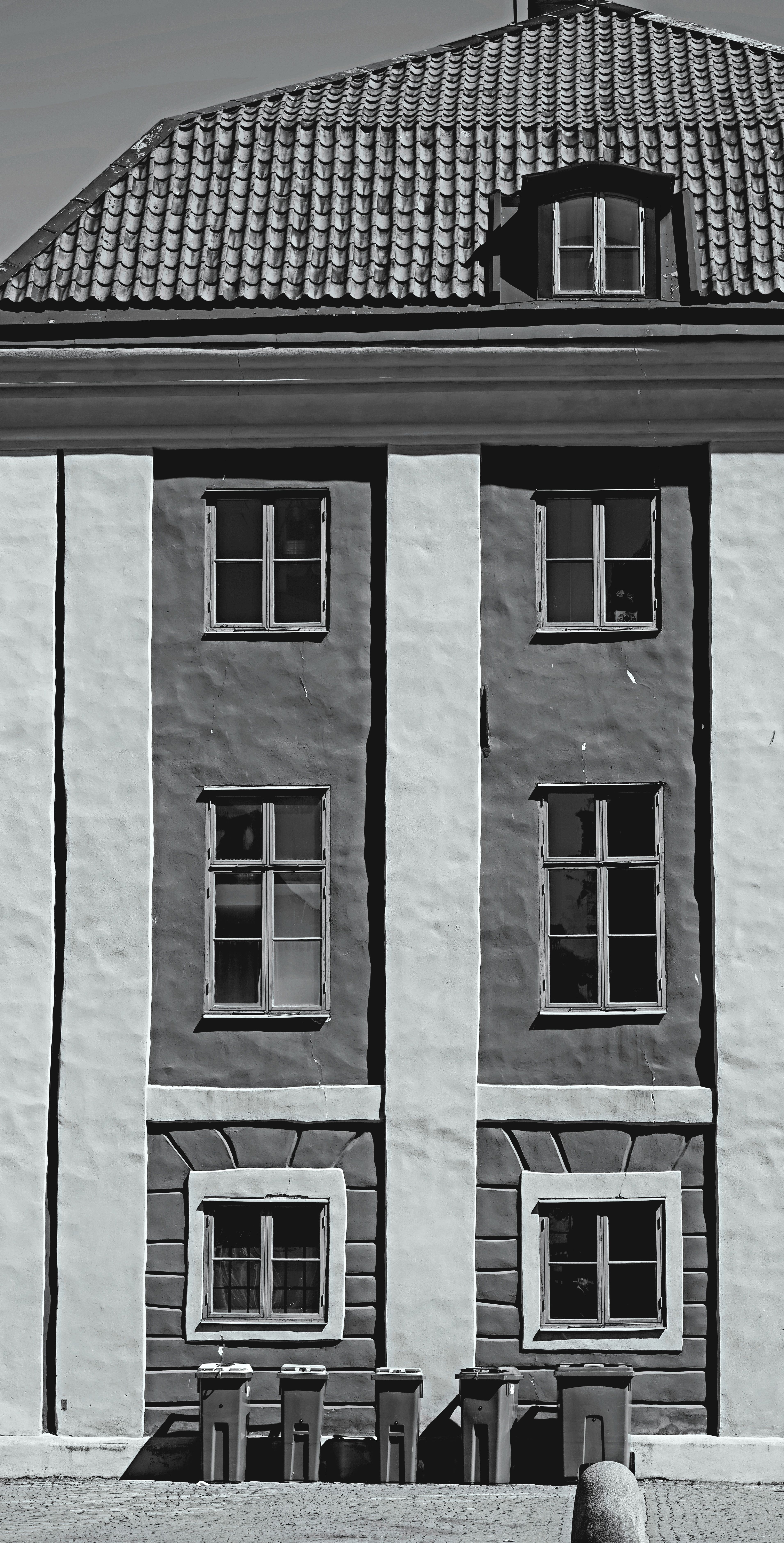 Black and white image of a traditional building exterior emphasizing symmetry and architecture.