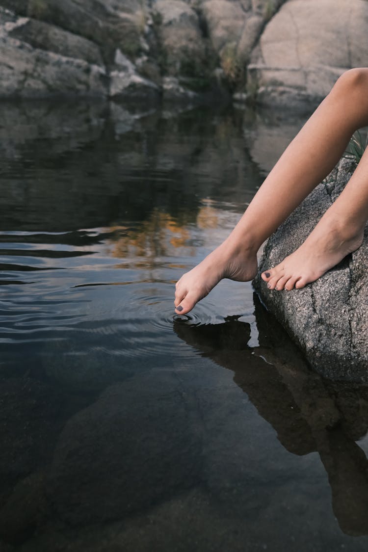 Woman Legs Touching A Lake Surface