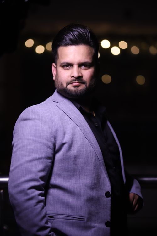 Free A striking portrait of a man in a suit posing confidently at night in Delhi, India. Stock Photo