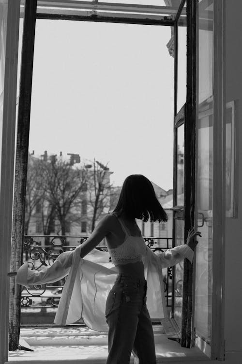 Brunette Woman in White Top Posing in Entrance to Balcony