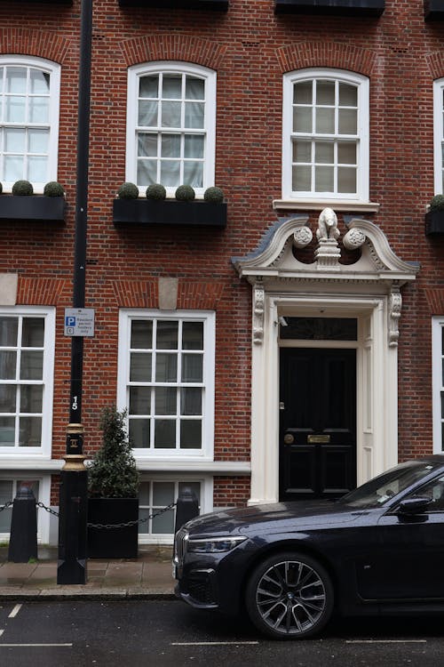 Facade of a Traditional House in London and a Modern Car Parked on the Side of the Street 
