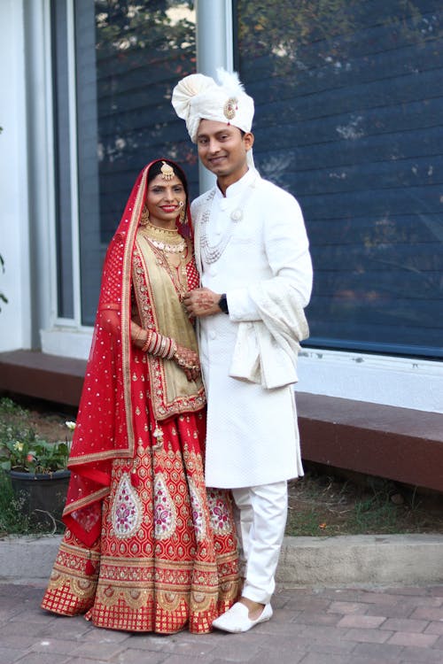 Bride and Groom in Traditional Clothing Standing Outside 