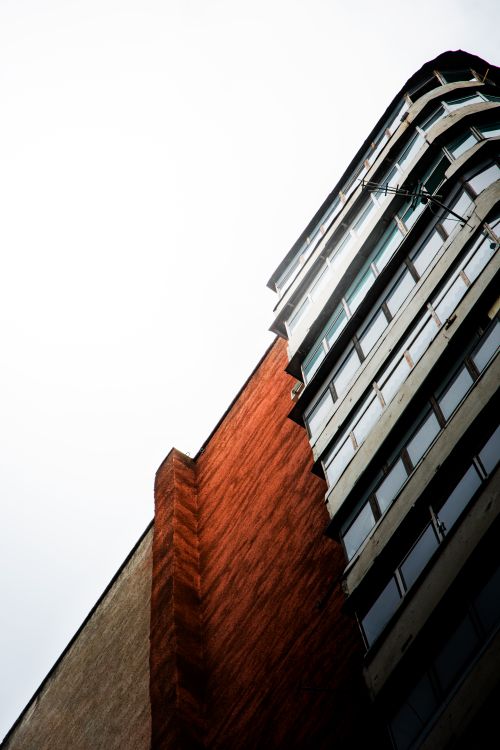 Free Striking low angle view of modern building facade contrasting with clear sky. Stock Photo
