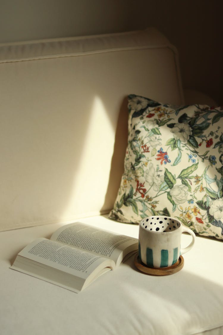 Open Book And Cup On Couch