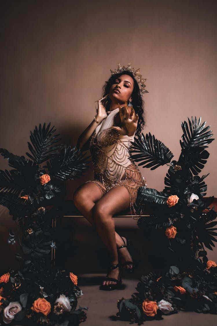 Woman In A Golden Dress And A Tiara Posing In Studio 