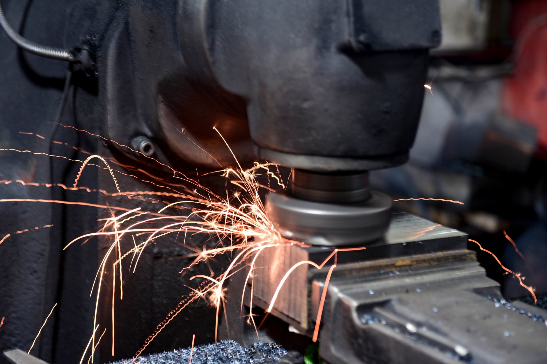 How Long Do Press Brake Dies Last Under Normal Use?插图1 Close-up of a grinding machine in action with sparks flying in an industrial setting.