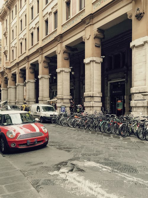 Bicycles and Cars Parked in front of a Building 