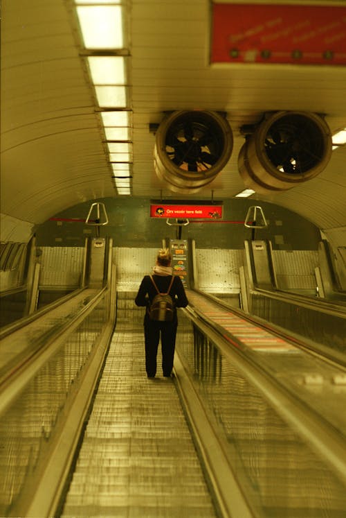 Woman Standing on Escalator at Subway