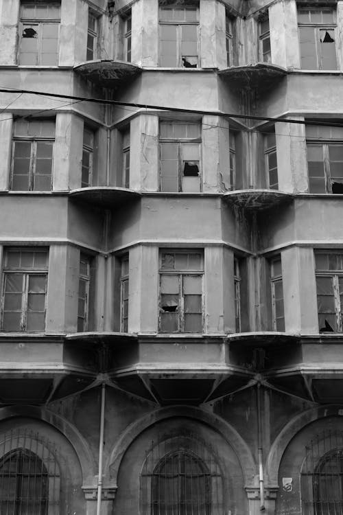 Facade of an Abandoned Building with Broken Windows in City 