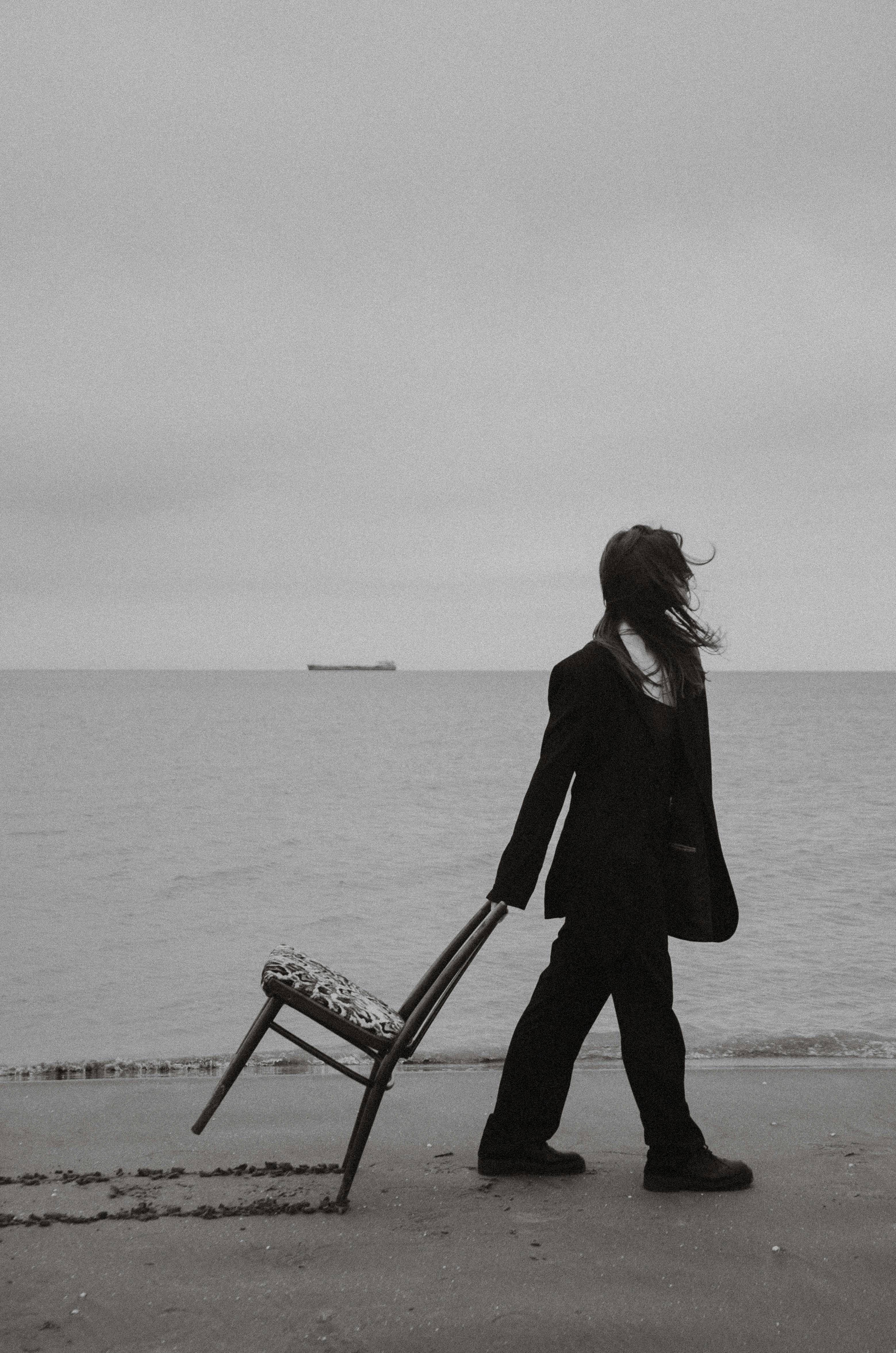 woman pulling chair on beach