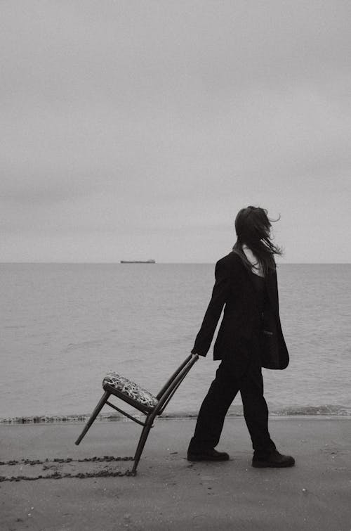 Woman Pulling Chair on Beach