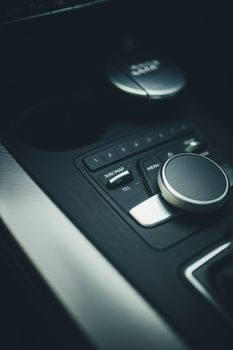 Detailed view of electronic controls in a modern car interior featuring navigation and audio settings.