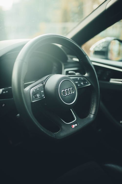 Free Close-up view of a luxury car steering wheel highlighting elegant design and premium craftsmanship. Stock Photo