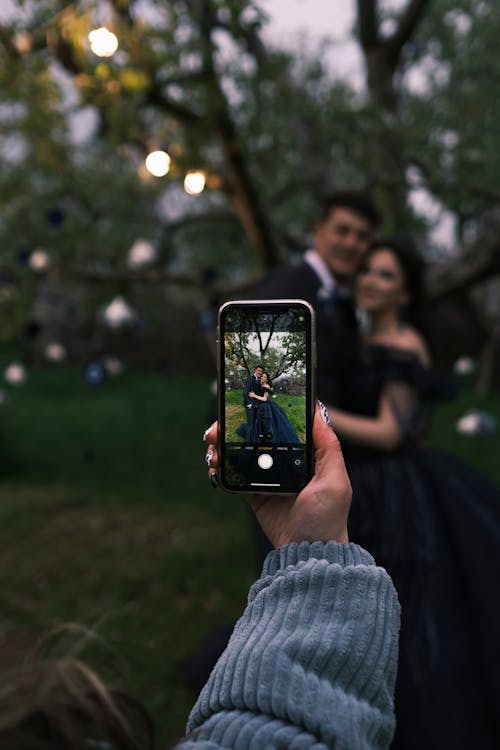 Hand Taking Pictures of Couple