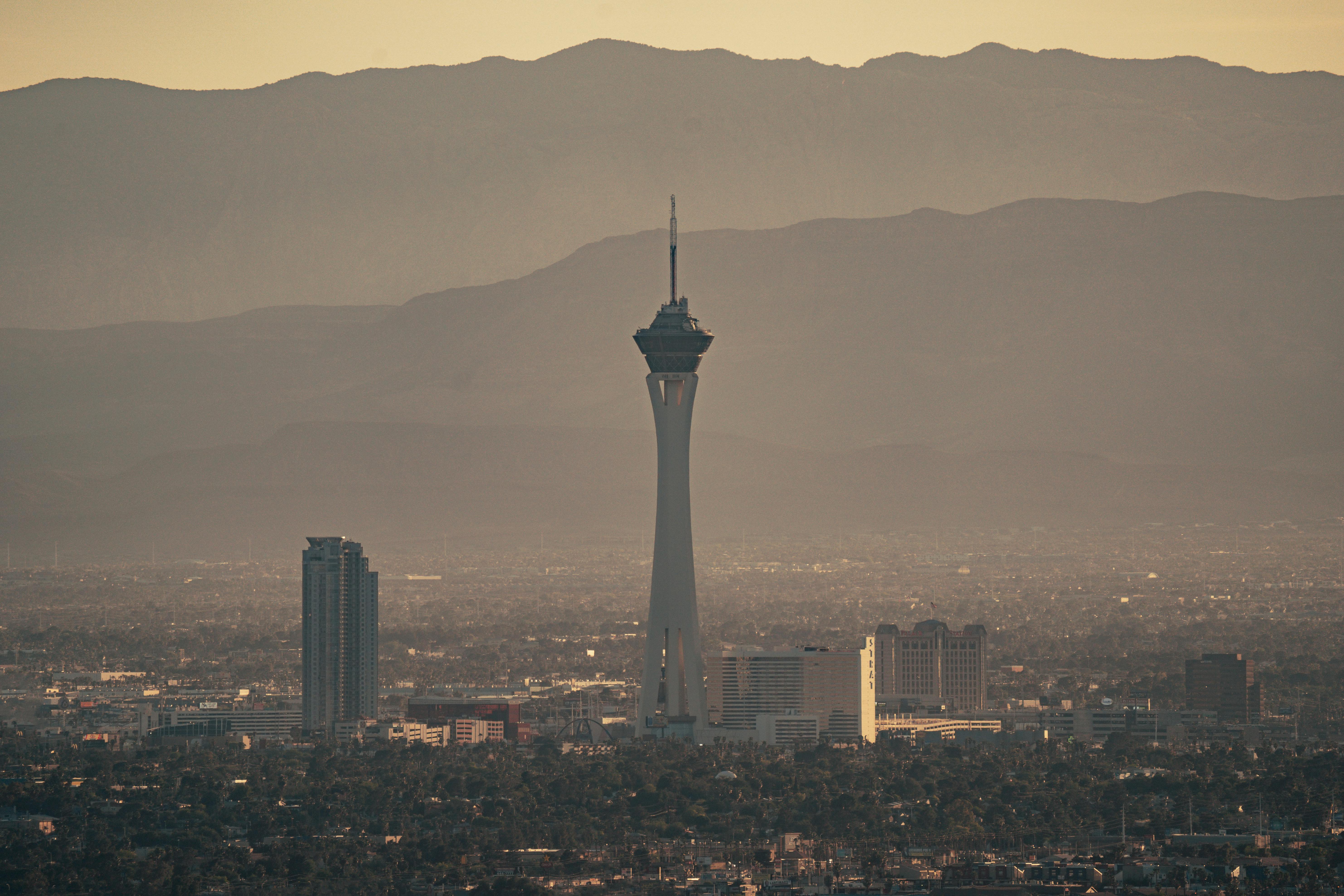Aerial view of the Stratosphere Tower amidst Las Vegas cityscape during twilight.