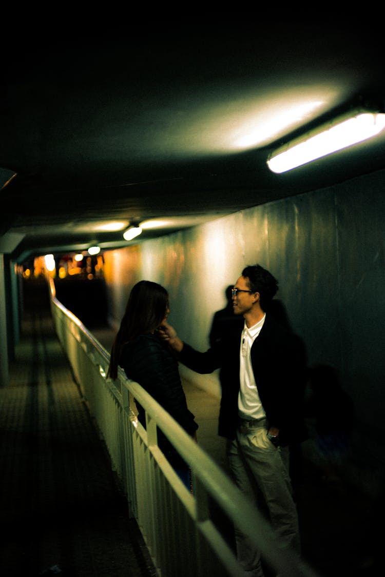 Man Touching Woman Chin In Underground Corridor