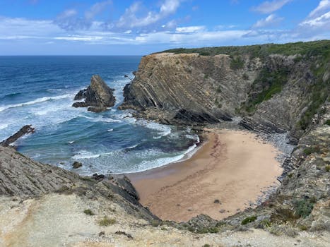 Dramatic cliffs and secluded beach in Alentejo, Portugal, overlooking the Atlantic Ocean.