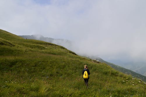 Hiker on Meadow in Mountains