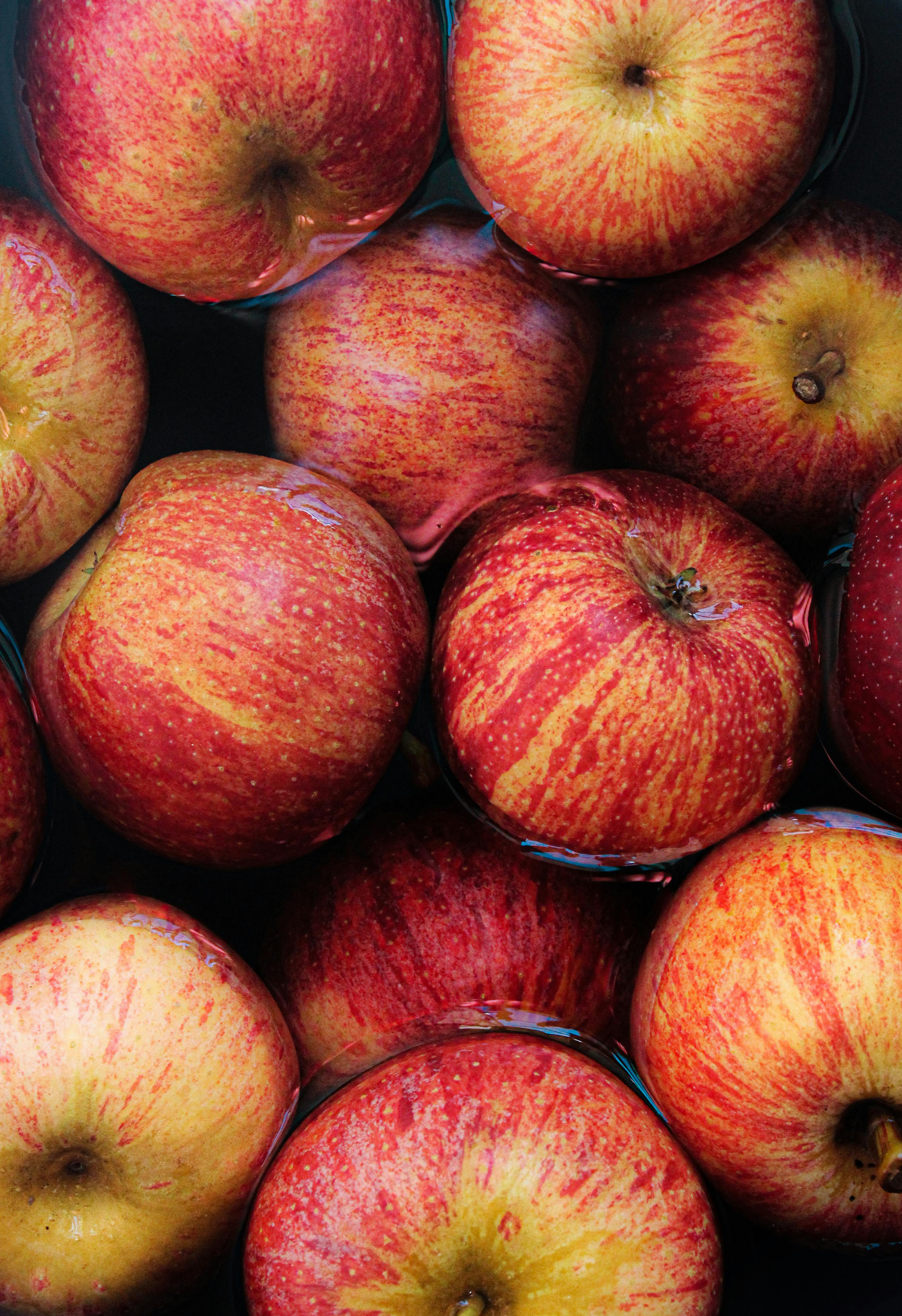 Vibrant red apples submerged in water, highlighting freshness and texture.