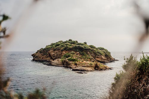 View of a Rocky Island near the Shore 