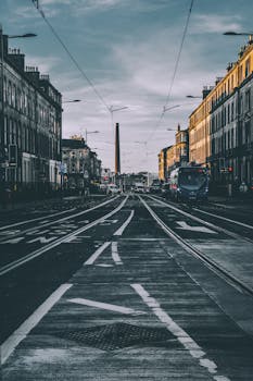 Tranquil city street with tram tracks and historic buildings at dusk.