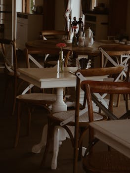 Warm and inviting cafe interior featuring wooden tables and chairs with elegant decor.