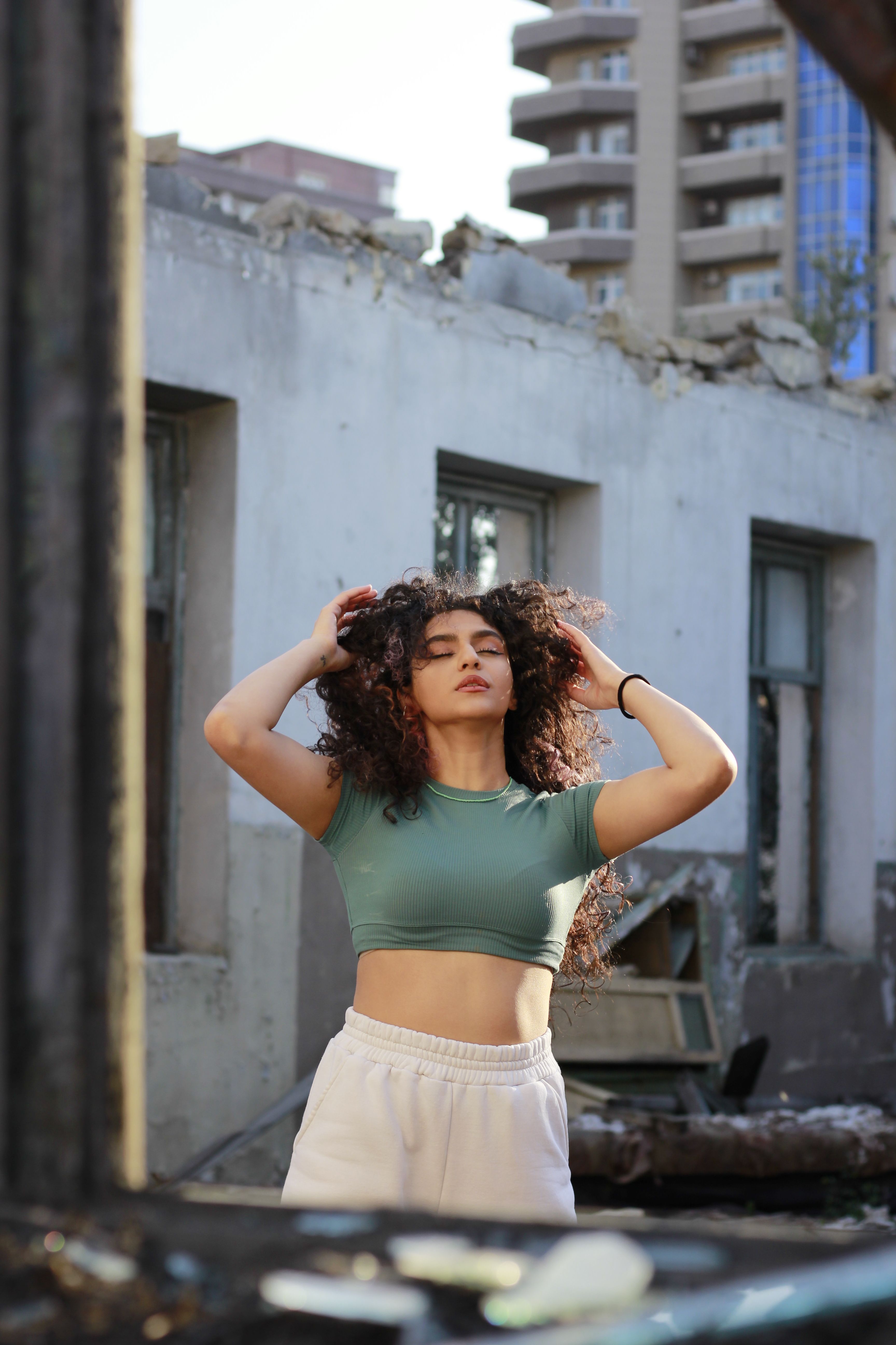 Woman with Curly Hair Posing on a Street · Free Stock Photo