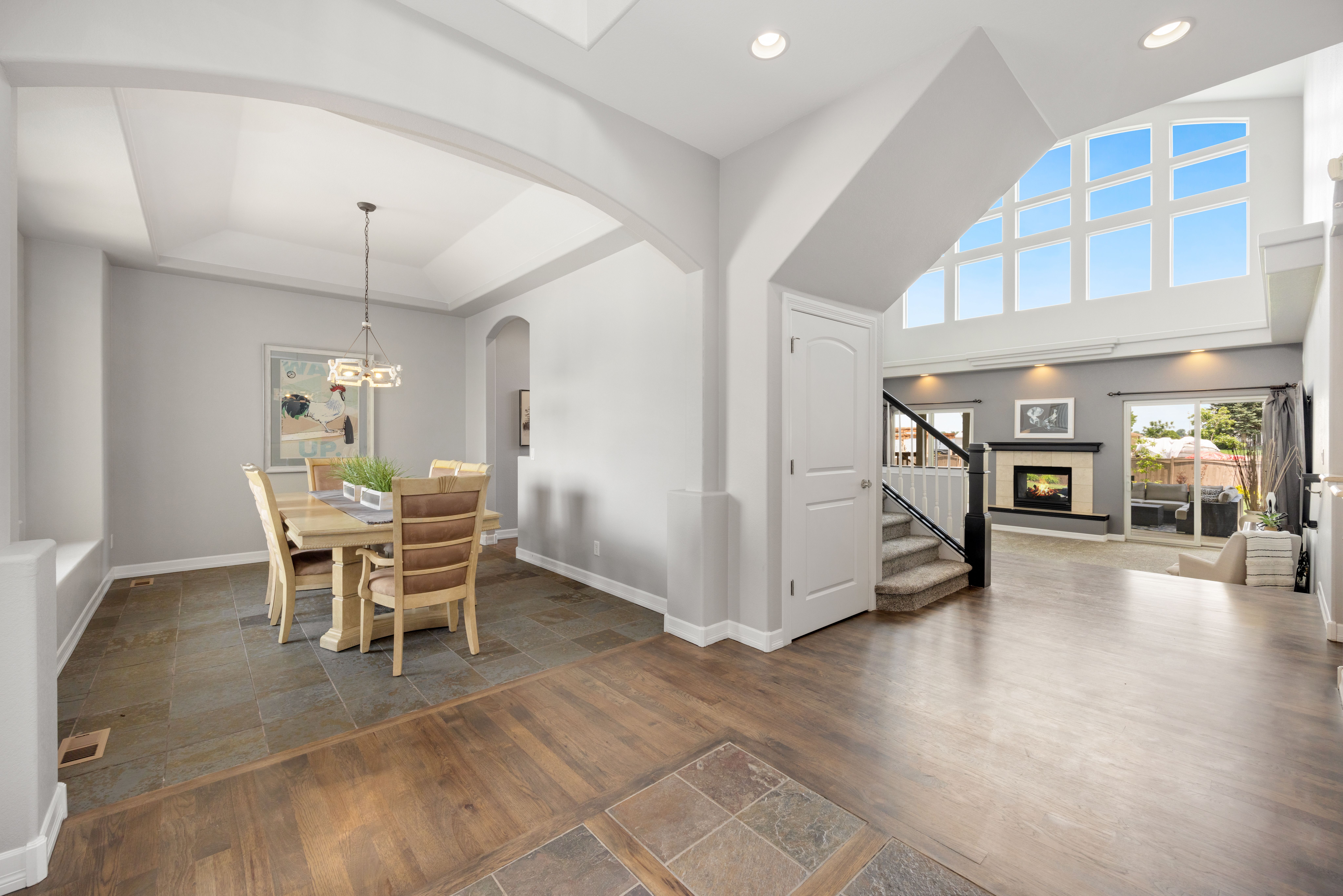 Bright open-concept dining and living room with fireplace