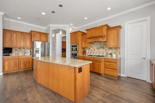 Free Bright kitchen featuring a granite island and wooden cabinetry, ideal for contemporary homes. Stock Photo