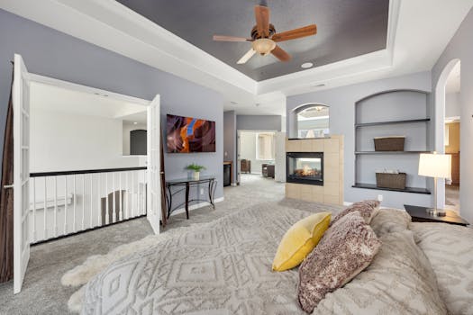 Spacious bedroom featuring a fireplace, stylish decor, and modern furnishings.