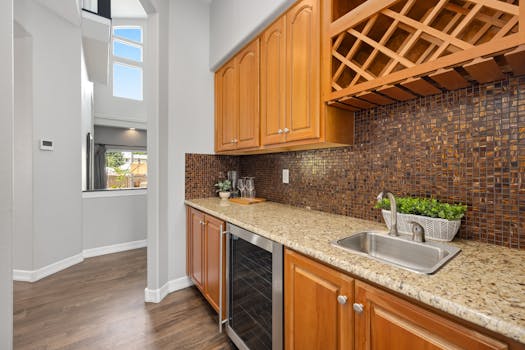 Elegant kitchen interior featuring granite countertops, wooden cabinets, and a mosaic backsplash.
