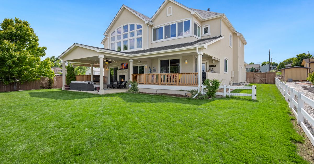 Beautiful two-story suburban house with a large green lawn and porch.