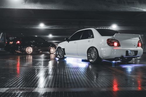 Free A white sports car with neon lights displayed in a modernized urban parking garage setting. Stock Photo