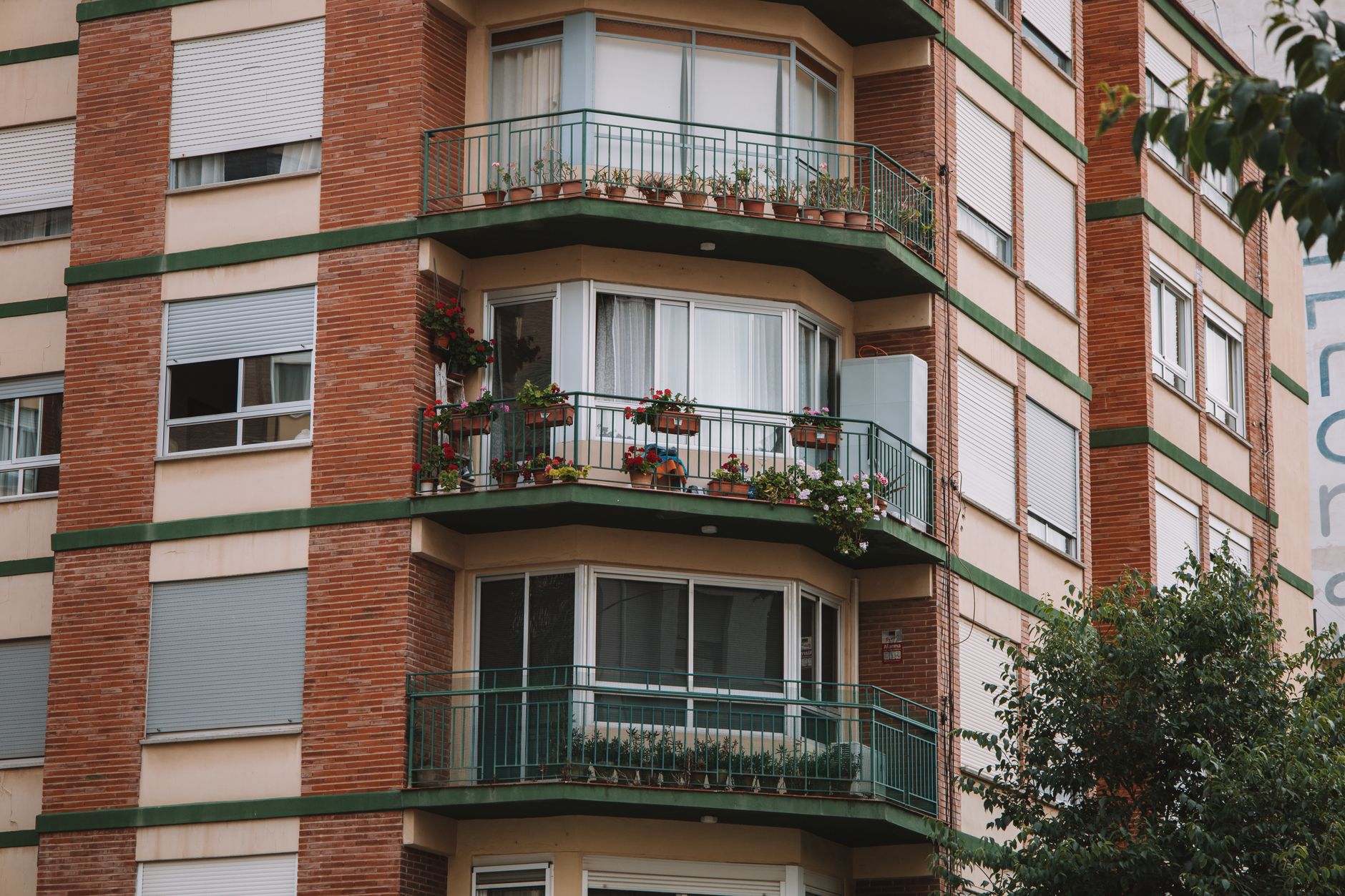 A beautiful urban building in Valencia with flower-adorned balconies and greenery, perfect for architectural themes.