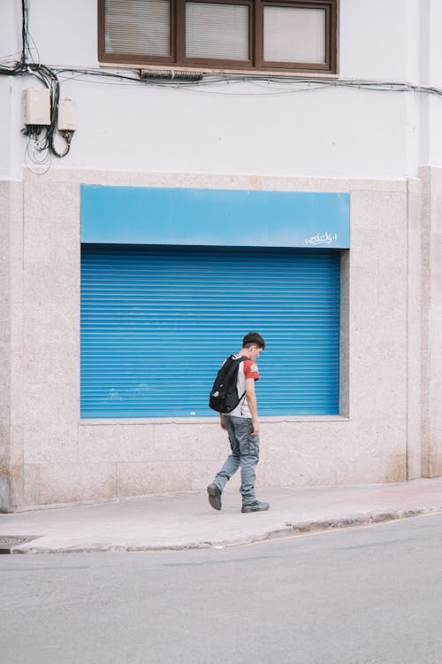 Boy with Backpack on Sidewalk