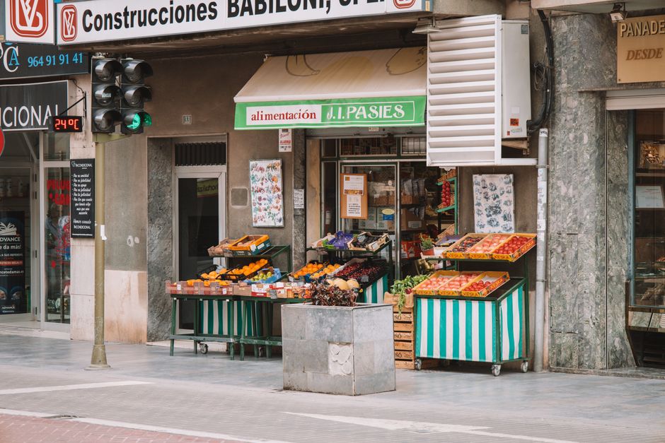 Colorido mercado callejero en Valencia, España, con frutas y verduras vibrantes.