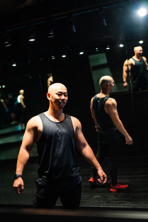 Free Bald athletic man in gym, reflected in mirrors, wearing sportswear. Stock Photo