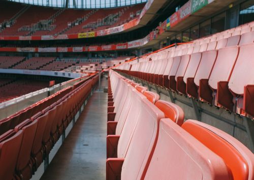 Free A perspective view of empty red seats at London's Emirates Stadium, a famous sports landmark. Stock Photo
