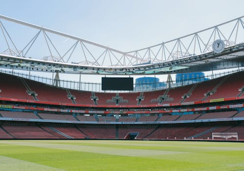 A view of the empty Emirates Stadium, home of Arsenal FC, under a clear sky in London.